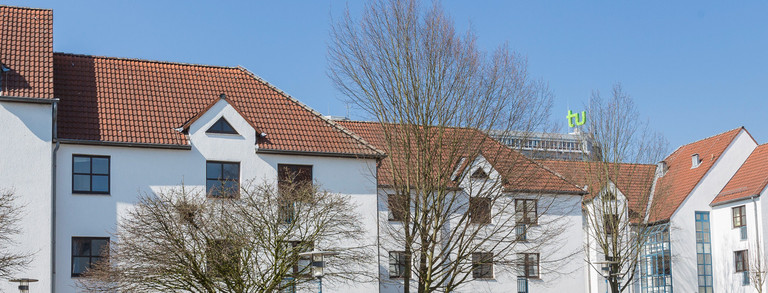 Studentendorf mit blauem Himmel und grünen Bäumen im Hintergrund